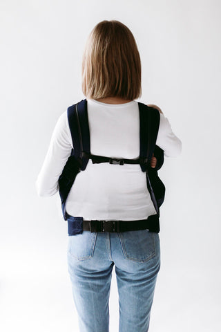 Woman carrying twins in Weego TWINS baby carrier. Back view.